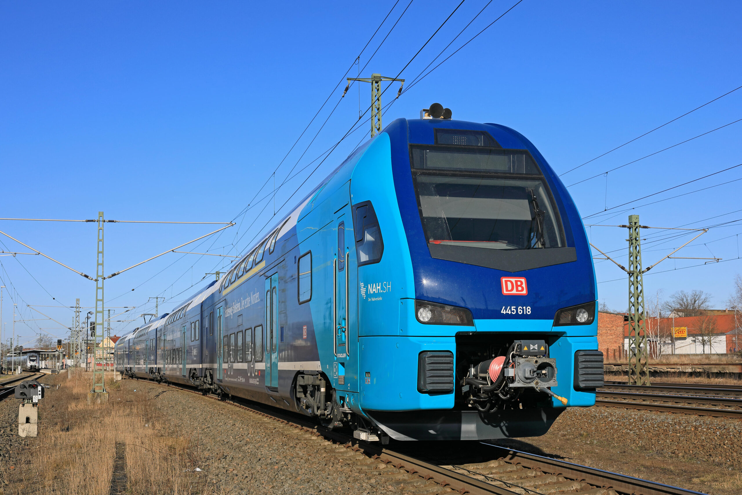 Od prosince 2022 bude pro NAH.SH GmbH na tzv. Elektronetz Ost jezdit 18 nových, elektricky poháněných dvoupatrových motorových vozů typu KISS od výrobce Stadler. EMU KISS pro operátora DB Regio mají sériové označení ET 445. (Na obrázku: Nový ET 445 při finálních testovacích jízdách výrobce v síti DB). Foto © DB AG / Uwe Miethe
