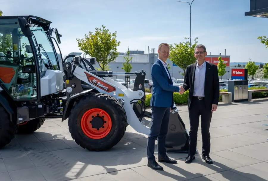 Pavel Svoboda, starosta města Dobříš (vlevo), přebírá kompaktní kolový nakladač Bobcat L85 od prezidenta společnosti Doosan Bobcat EMEA © Doosan Bobcat
