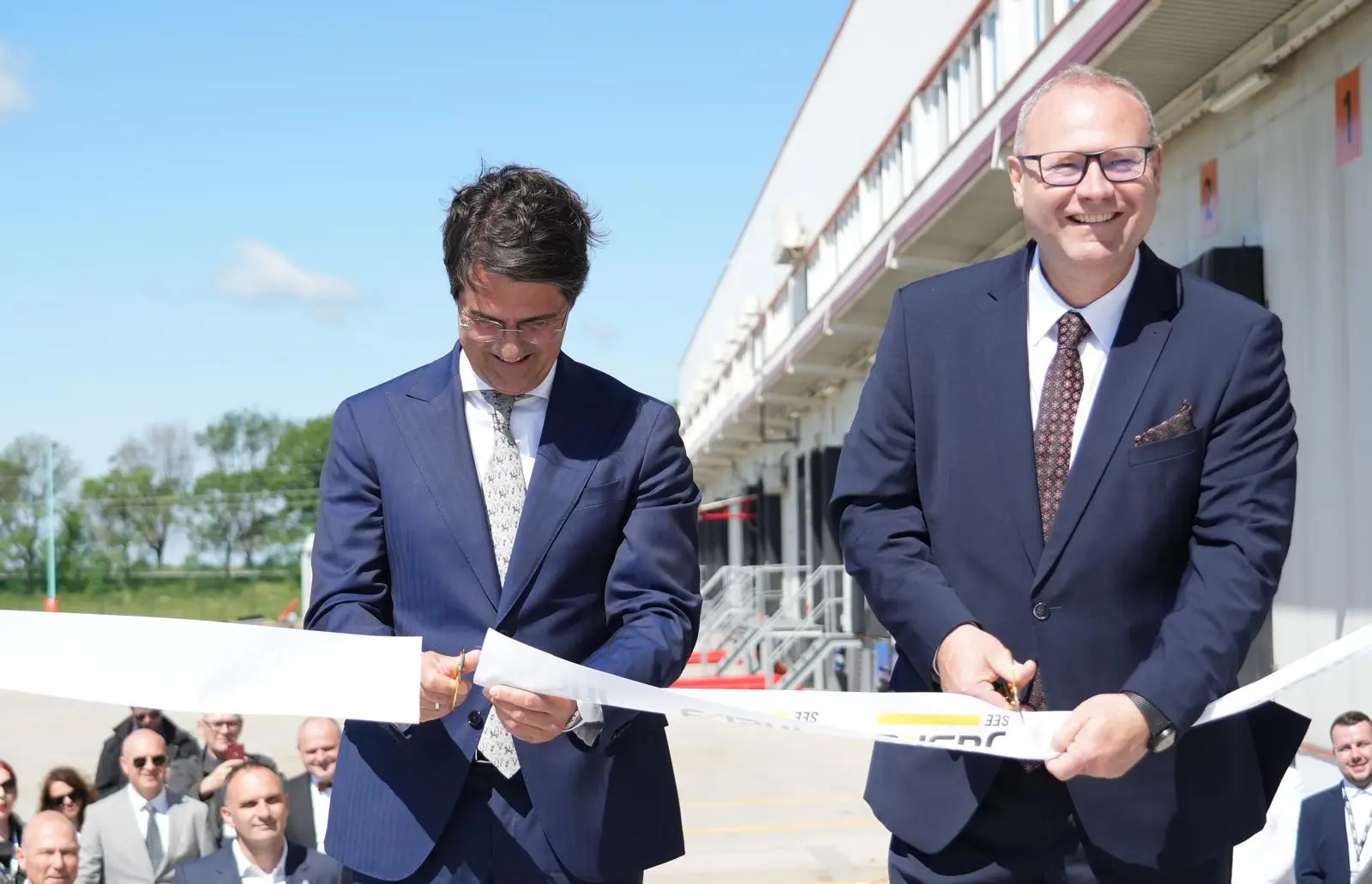 Petr Škoda, CEO společnosti JUSDA Europe, při střihání pásky nového ligistického centra v Sbrsku. zdroj JUSDA Europe